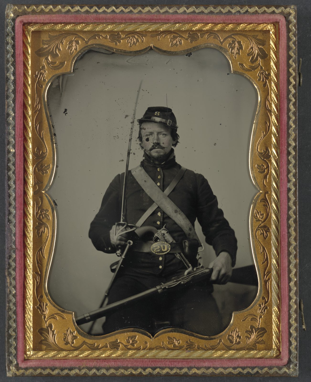 Unidentified soldier in Union uniform and Company B hat, with Hall breech loading carbine rifle, Colt revolver, and cavalry sword LCCN2012648979